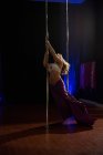 Bailarina polaca deportiva practicando pole dance en estudio - foto de stock