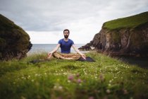 Mann macht Yoga auf Klippe — Stockfoto