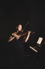 Студентка играет на скрипке в студии — стоковое фото