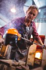 Glassblower forming and shaping a molten glass at glassblowing factory — Stock Photo