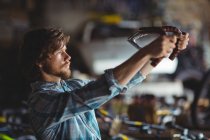 Mechanic examining a bicycle handle bar in workshop — Stock Photo