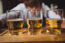 Bartender forro copos de uísque tiro no balcão bar no bar — Fotografia de Stock