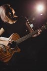 Female student playing guitar in a studio — Stock Photo