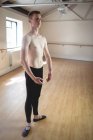 Без рубашки красивый балерино стоит в студии и смотрит в сторону — стоковое фото