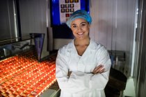 Портрет жіночого персоналу, що стоїть з обіймами, схрещеними на яєчній фабриці — стокове фото