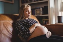 Mulher grávida relaxante na sala de estar em casa — Fotografia de Stock