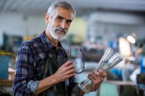 Portrait of glassblower holding glass vase at glassblowing factory — Stock Photo