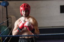 Boxer muscoloso senza maglietta che pratica pugilato in palestra — Foto stock