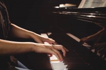 Metà sezione di studentessa che suona il pianoforte in uno studio — Foto stock