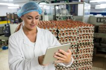 Женщины-сотрудники используют цифровые планшеты на яйцефабрике — стоковое фото