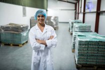 Ritratto di bastone femminile in piedi con le braccia incrociate in fabbrica di uova — Foto stock