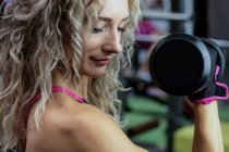 Nahaufnahme der schönen Frau beim Hantelheben im Fitnessstudio — Stockfoto