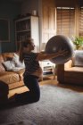 Вид збоку Вагітна жінка займається фітнес-кулькою у вітальні вдома — стокове фото