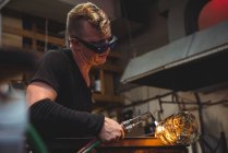 Митець, даючи остаточний доторкнутися до шматка скла з glassblowing факел на заводі glassblowing — стокове фото
