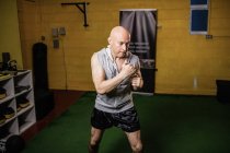 Vue grand angle de la formation boxer thaïlandais beau dans la salle de gym — Photo de stock