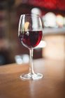 Primo piano di vetro con vino rosso in tavola al bar — Foto stock