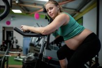 Портрет вагітної жінки працювати на велосипеді вправи в тренажерному залі — стокове фото