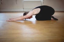 Vista laterale di Ballerino che esegue esercizio di stretching in studio — Foto stock