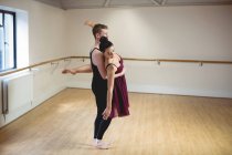 Sportive Ballet partners dancing together in modern studio — Stock Photo