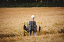 Scarecrow in wheat field on sunny day — Stock Photo