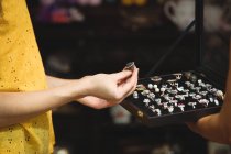 Hands of woman looking at a vintage rings in antique shop — Stock Photo