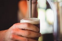 Primo piano del bar tender che riempie la birra dalla pompa bar al bancone del bar — Foto stock