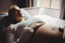 Selektiver Fokus der Schwangeren, die sich zu Hause im Schlafzimmer entspannen — Stockfoto