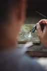 Nahaufnahme einer Handwerkerin mit Taschenlampe in Werkstatt — Stockfoto