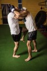 Вид сбоку двух тайских боксеров, занимающихся в тренажерном зале — стоковое фото