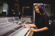 Estudante feminina usando misturador de som em um estúdio — Fotografia de Stock