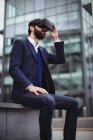 Uomo d'affari utilizzando cuffie realtà virtuale al di fuori dell'ufficio — Foto stock