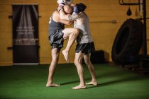 Vue latérale de deux boxeurs thaïlandais pratiquant dans la salle de gym — Photo de stock