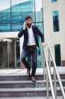 Uomo d'affari che parla sul cellulare mentre cammina sulle scale — Foto stock