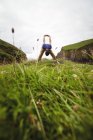 Человек, выполняющий упражнения на растяжку на скале — стоковое фото