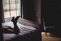 Женщина лежит на кровати в спальне дома — стоковое фото