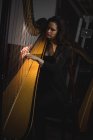 Donna attenta suonare un'arpa nella scuola di musica — Foto stock