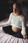 Donna incinta che esegue yoga in camera da letto a casa — Foto stock