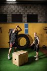 Два спортсмени, що працюють на дерев'яній коробці у фітнес-студії — стокове фото