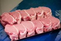 Steaks crus gardés sur le plateau à la boucherie — Photo de stock