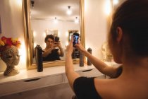 Жінка бере селфі з мобільного телефону в салоні краси — стокове фото