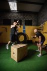 Zwei Sportler üben auf Holzkiste im Fitnessstudio — Stockfoto
