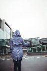 Rückansicht einer Frau, die während der Regenzeit auf der Straße steht — Stockfoto