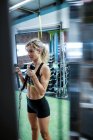 Женщина выполняет упражнения на растяжку в тренажерном зале — стоковое фото