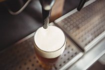Close-up de copo de cerveja com espuma em um bar — Fotografia de Stock