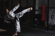Seitenansicht einer Frau, die Karate im Fitnessstudio praktiziert — Stockfoto