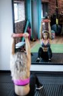Spiegelbild der schönen Frau, die im Fitnessstudio trainiert — Stockfoto