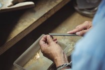 Hands of craftswoman using tool in workshop — Stock Photo