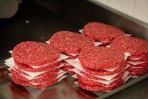 Primer plano de hamburguesas crudas en carnicería - foto de stock