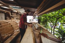 Mann arbeitet auf Holzplanke in Bootswerft — Stockfoto