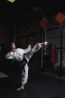 Donna che pratica karate in palestra — Foto stock